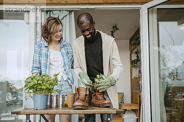 Glückliches multirassisches Paar bei der Gartenarbeit vor dem Haus