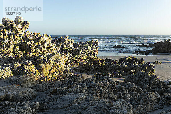 Südafrika  Hermanus  raue Felsen am Voelklip Strand und Meer im Hintergrund