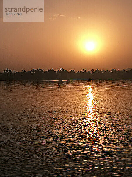 Ägypten  Luxor  untergehende Sonne  die sich im Nil spiegelt