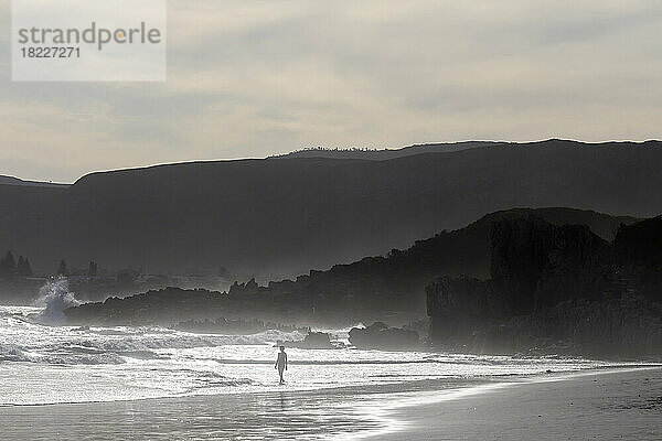 Südafrika  Hermanus  Silhouette eines Jungen (8-9) an einem Grotto Beach