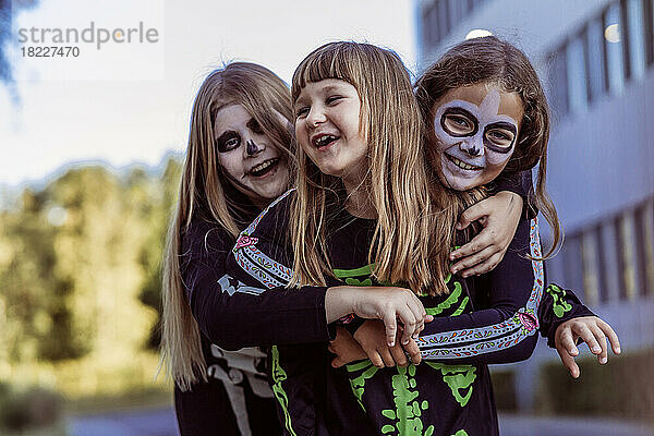 Kinder feiern eine Halloween-Kostümparty im Hintergarten