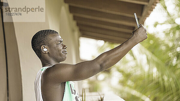 Afroamerikanischer Mann macht Selfie auf der Terrasse