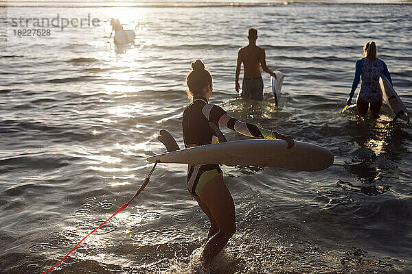 Junge Frau mit Surfbrett am Strand