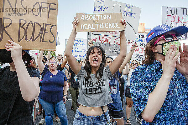 Eine wütende Frau steht in der Menschenmenge und hält bei einer Kundgebung ein Pro-Choice-Schild in der Hand