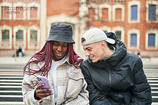 Porträt eines multiethnischen Paares  das auf der Straße telefoniert
