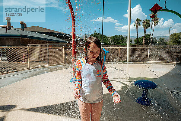Glückliches Kind  das an einem sonnigen Tag in einem Wasserpark spielt