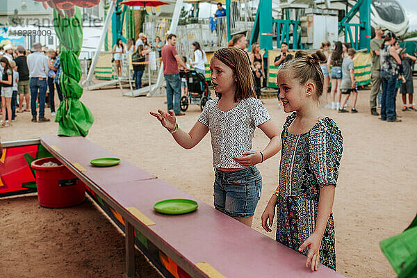 Zwei junge Mädchen spielen Karnevalsspiele auf dem Jahrmarkt