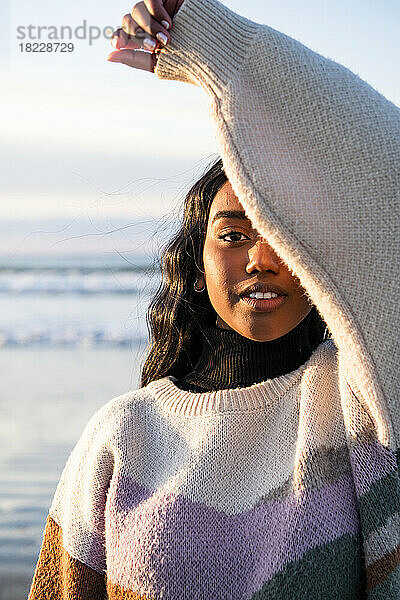 Porträt einer jungen indischen Frau am Strand  die in die Kamera blickt