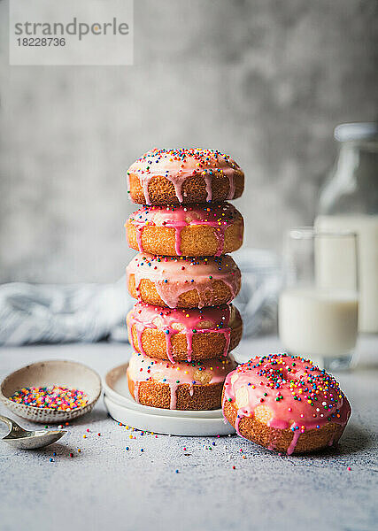 Stapel Vanillekuchen-Donuts mit rosa Zuckerguss und Streuseln.