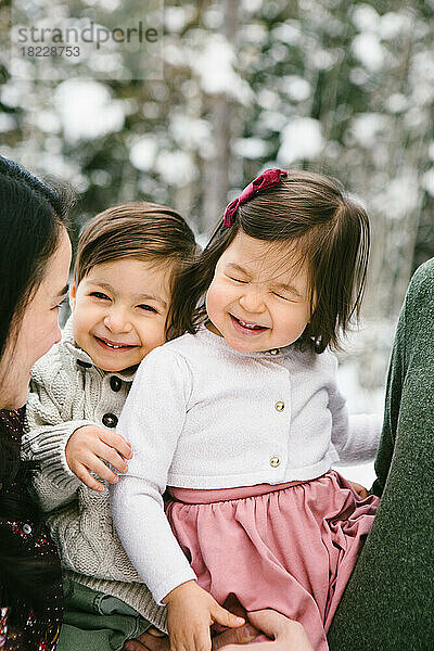 Kleinkind-Bruder und -Schwester lachen und lächeln im verschneiten Wald