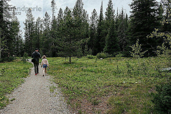 Vater und Tochter gehen den Wanderweg im Wald entlang
