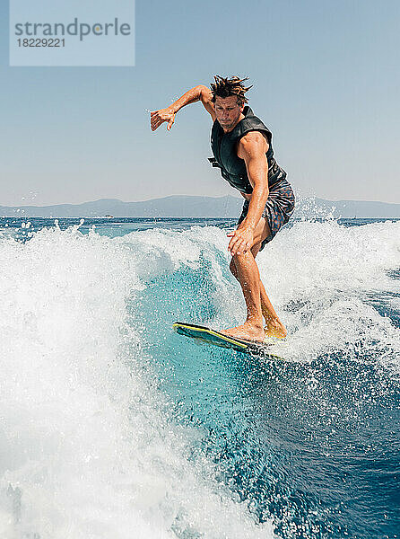 Mann beim Wakeboarden am See