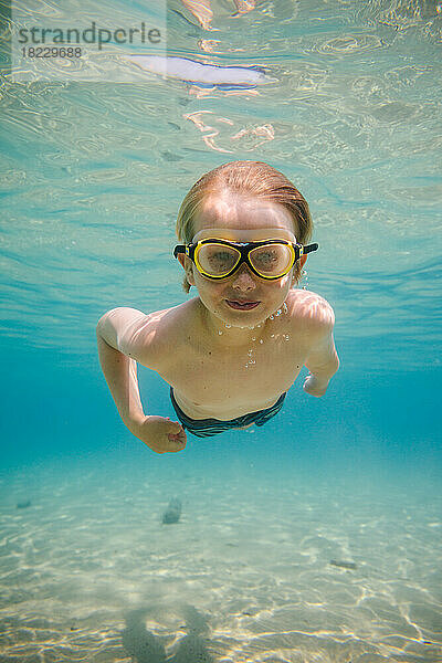 Porträt eines Jungen (8-9)  der unter Wasser schwimmt
