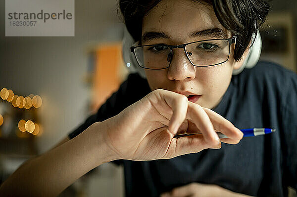 Junge mit Brille und Stift zu Hause