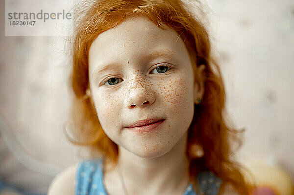 Smiling redhead girl with freckles on face
