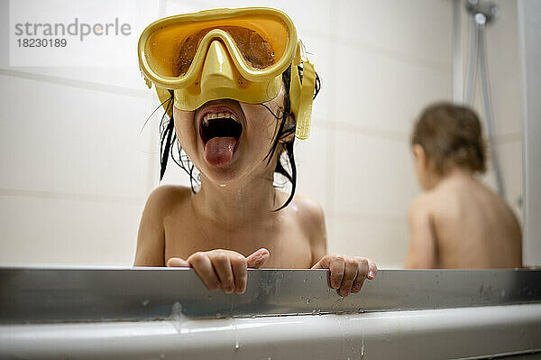 Junge mit Schwimmbrille badet im Badezimmer