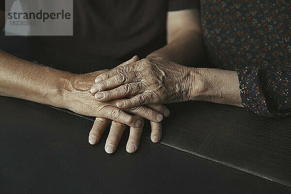 Älteres Paar stapelt die Hände auf dem Tisch