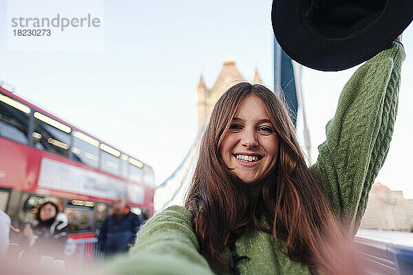 Glückliche Frau im grünen Pullover macht ein Selfie auf der Tower Bridge  London  England