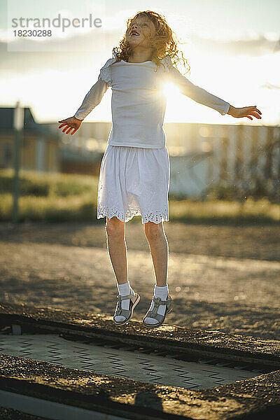 Glückliches Mädchen springt auf Trampolin im Park