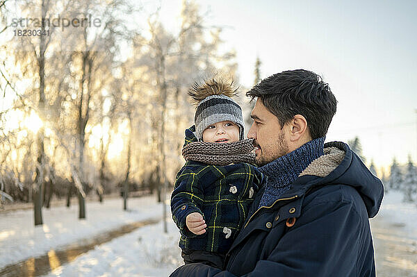 Vater trägt Sohn im Winterpark