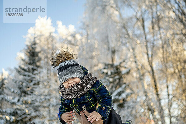 Fröhlicher Junge genießt den Winterpark