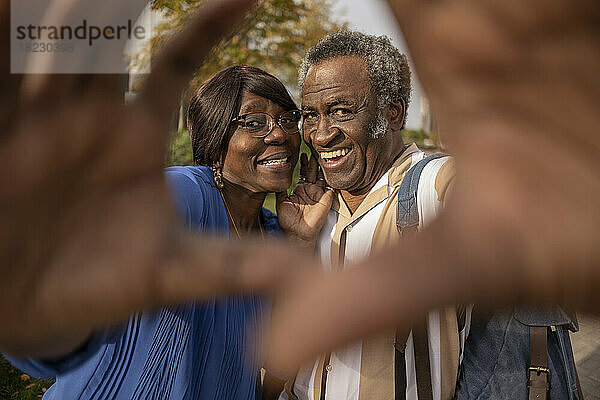 Glückliches älteres Paar gestikuliert im Park