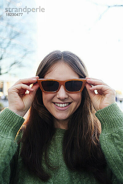 Glückliche junge Frau mit Sonnenbrille