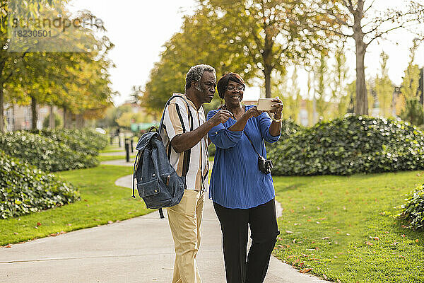 Älteres Paar benutzt Mobiltelefon im Park