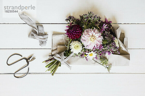 Studio shot of bouquet of three varieties of dahlias mixed with other flowers