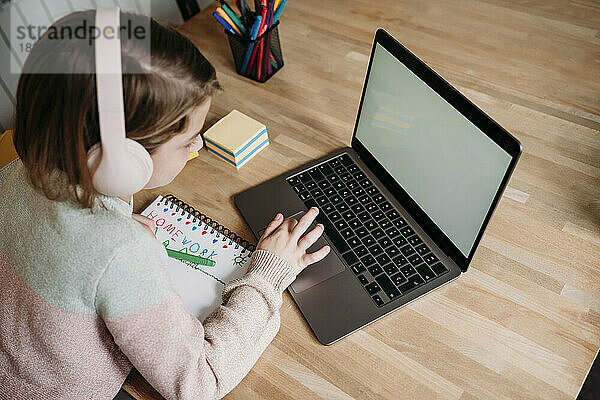 Mädchen lernt mit Laptop auf dem Tisch