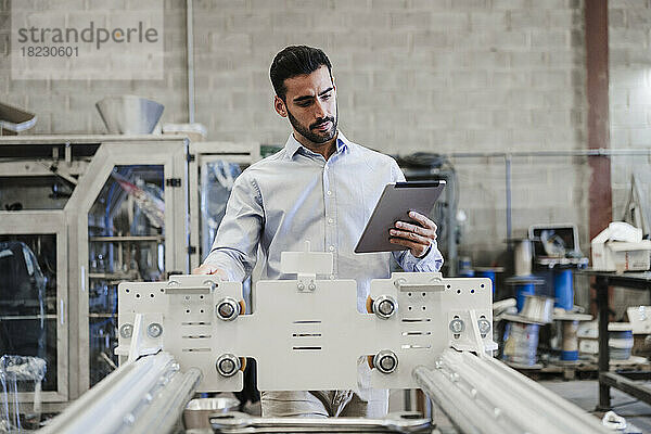 Ingenieur nutzt Tablet-PC und Bedienmaschine in der Industrie