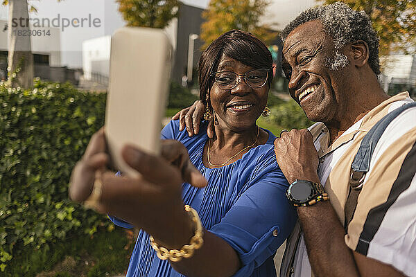 Glückliches älteres Paar  das im Park ein Selfie mit dem Smartphone macht