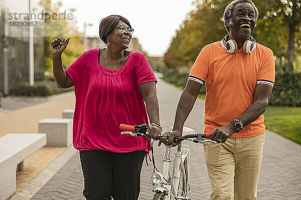 Glückliches Seniorenpaar fährt gemeinsam Fahrrad im Park