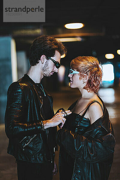 Affectionate boyfriend and girlfriend at illuminated underpass