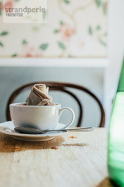 Leere Kaffeetasse mit zerknitterter Serviette auf dem Tisch