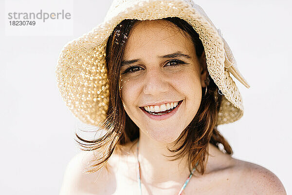 Porträt einer glücklichen jungen Frau mit Hut