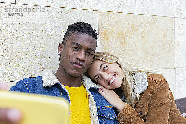 Lächelnde Frau und Mann machen Selfie per Smartphone