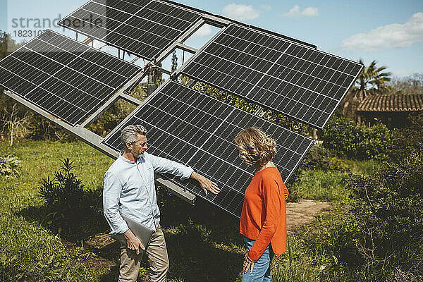 Reife Frau und Mann diskutieren über Sonnenkollektoren