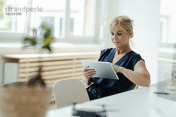 Reife Geschäftsfrau nutzt Tablet-PC im Büro