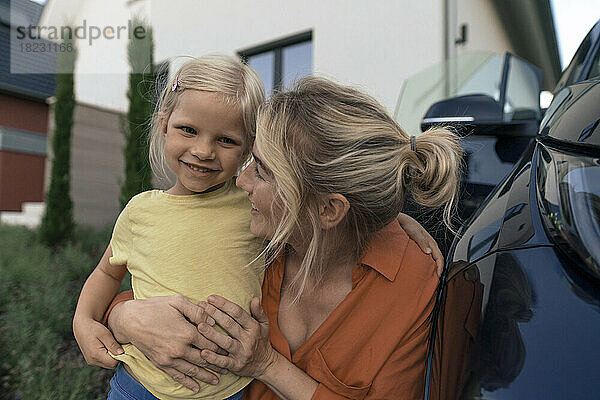 Glückliche Mutter umarmt Tochter im Auto