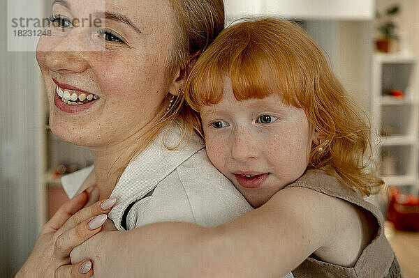 Glückliche Tochter umarmt Mutter zu Hause