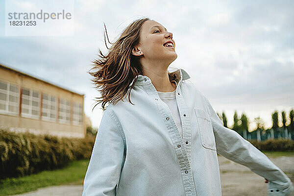 Carefree teenage girl enjoying on schoolyard