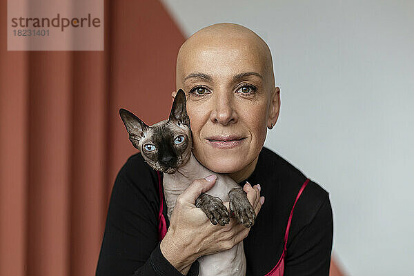 Frau mit Glatze umarmt haarlose Sphynx-Katze