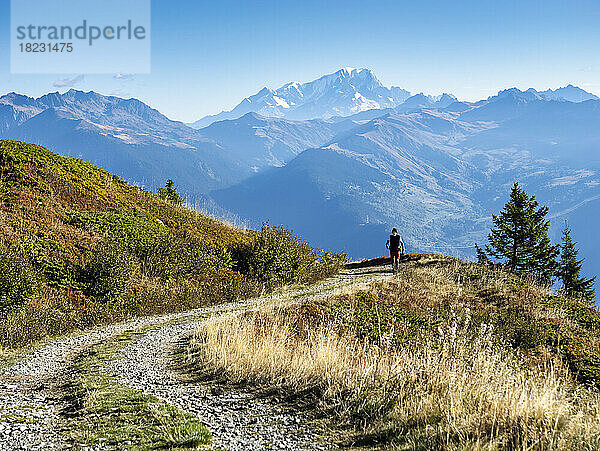 Mann  der an einem sonnigen Tag vor den Bergen im Nationalpark Vanoise  Frankreich  spaziert