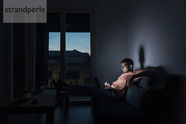 Young man using laptop in room at home