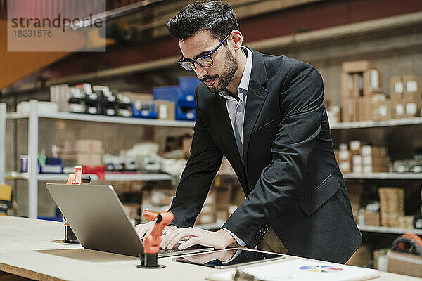 Geschäftsmann arbeitet am Laptop in der Industrie