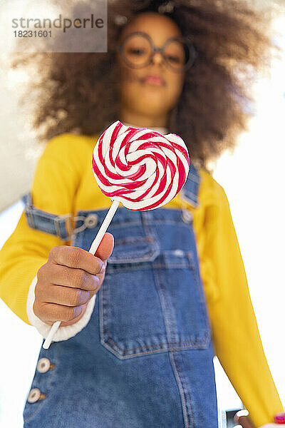 Girl holding lollipop with missing bite