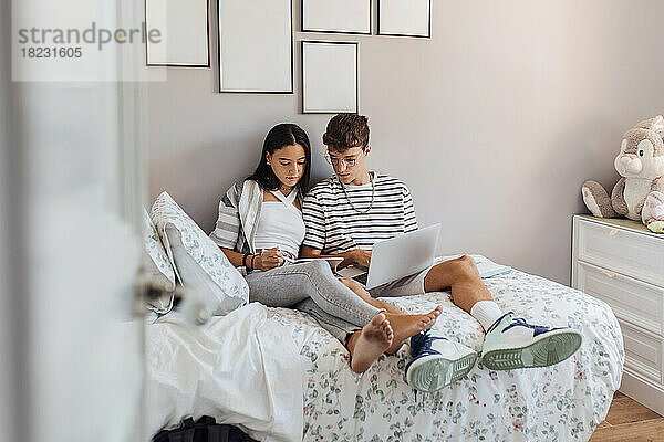 Geschwister lernen zu Hause am Tablet-PC im Schlafzimmer