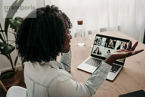 Geschäftsfrau führt Videoanrufe mit Kollegen am Laptop im Heimbüro