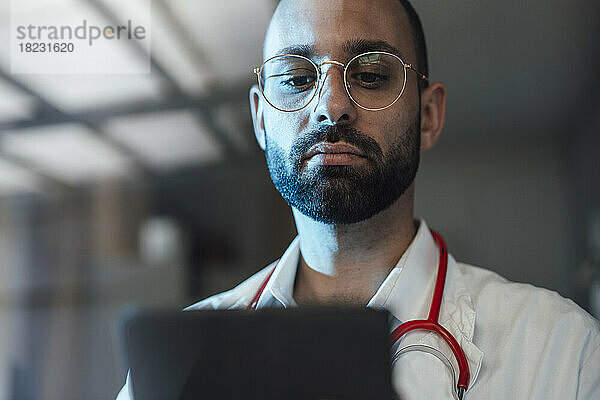 Arzt schaut im Krankenhaus auf Tablet-PC